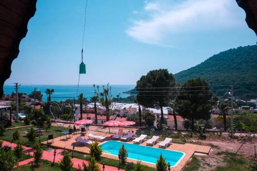 a view of a resort with a swimming pool and the ocean at karaöz lighthouse bungalow in Kumluca