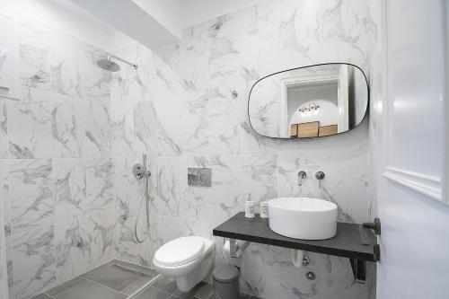a white bathroom with a sink and a mirror at Alexia Studios in Kolios