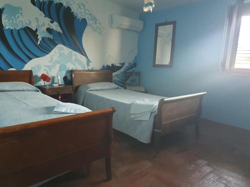 ein Schlafzimmer mit 2 Betten und einer blauen Wand in der Unterkunft Al Rifugio in Montecorvino Pugliano