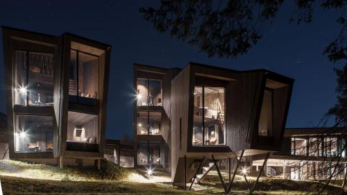 un bâtiment avec des fenêtres éclairées la nuit dans l'établissement Elva Hotel, à Skulestadmo