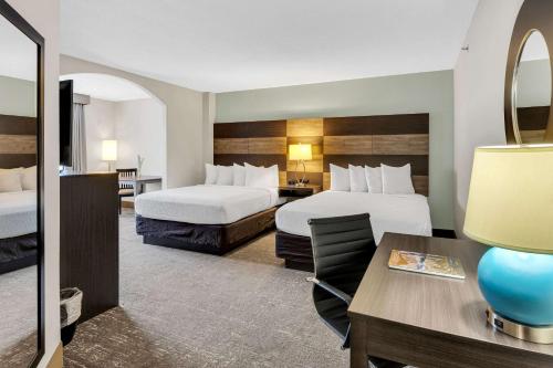 a hotel room with two beds and a desk at Country Inn & Suites by Radisson Rehoboth Beach - Dewey in Rehoboth Beach
