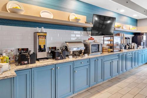 a kitchen with blue cabinets and a counter at Country Inn & Suites by Radisson Rehoboth Beach - Dewey in Rehoboth Beach