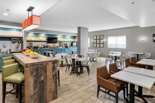 un restaurante con mesas y sillas y una cafetería en Country Inn & Suites by Radisson Rehoboth Beach - Dewey, en Rehoboth Beach