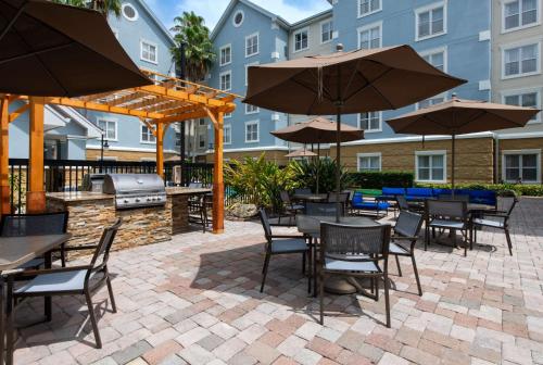 a patio with tables and chairs and an outdoor grill at Homewood Suites by Hilton Lake Mary Orlando North in Lake Mary