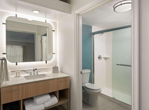 a bathroom with a sink and a toilet and a mirror at Homewood Suites by Hilton Lake Mary in Lake Mary