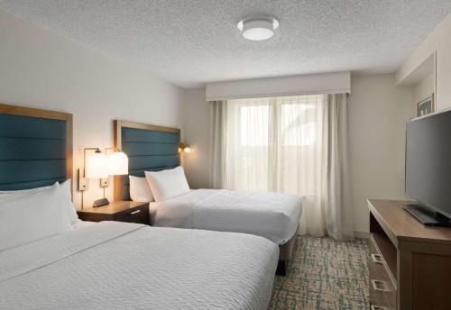 Habitación de hotel con 2 camas y TV de pantalla plana. en Homewood Suites by Hilton Lake Mary, en Lake Mary