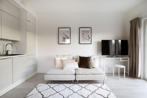 un soggiorno bianco con divano e TV di Top Floor Tarutie a Kirkkonummi