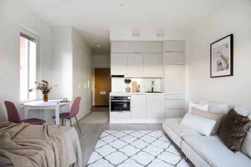 a white living room with a couch and a table at Top Floor Tarutie in Kirkkonummi