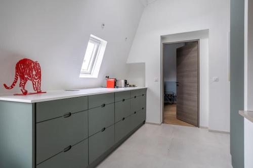 a kitchen with a red dinosaur figurine on a counter at Appartement de 100m2 dans un parc à 20 mn du centre de Paris in Garches