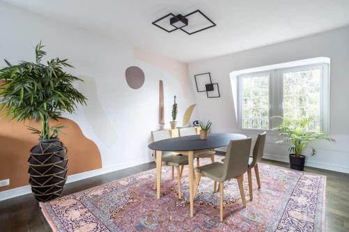 une salle à manger avec une table et des chaises dans l'établissement Appartement de 100m2 dans un parc à 20 mn du centre de Paris, à Garches