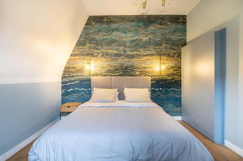 a bedroom with a large bed with a painting on the wall at La Quinta in Garches
