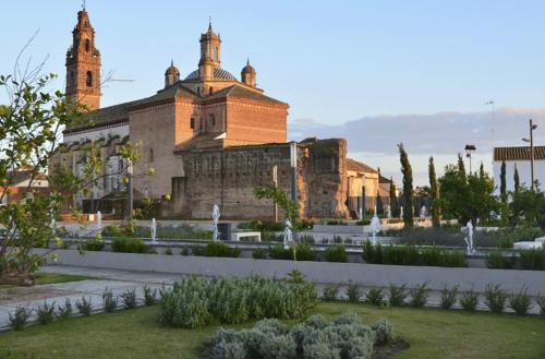 a large building with a garden in front of it at Hospedería Convento de Santa Clara in Palma del Río