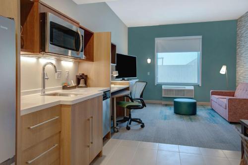 a kitchen with a sink and a desk in a room at Home2 Suites By Hilton Las Vegas North in Las Vegas