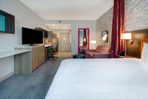 拉斯维加斯Home2 Suites By Hilton Las Vegas North的配有一张大床和一台平板电视的酒店房间
