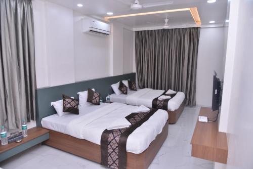 ein Hotelzimmer mit 2 Betten und einem TV in der Unterkunft HOTEL D SQUARE . in Shirdi