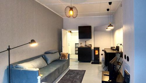 Il comprend un salon avec un canapé bleu et une cuisine. dans l'établissement Lossikambri külaliskorterid, à Viljandi