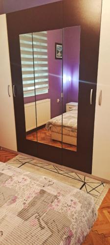a mirror in a room with a bed at Apartman Žile in Bačka Palanka