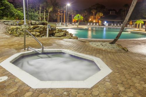 a hot tub in the middle of a pool at night at Legacy Vacation Resorts - Palm Coast in Palm Coast