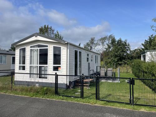 a white tiny house on the side of a road at NV 1013 - Beach Resort Nieuwvliet Bad in Nieuwvliet