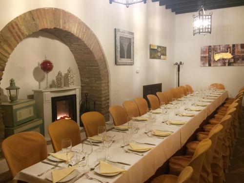 a long table in a room with chairs and a fireplace at Hospedería Convento de Santa Clara in Palma del Río