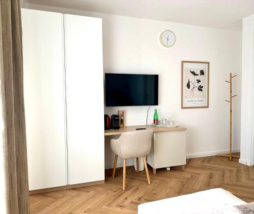 a living room with a desk and a tv at morand I Apartments in Salzburg