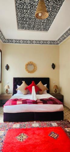 a bedroom with a large bed with a red rug at Riad Amazing in Marrakech