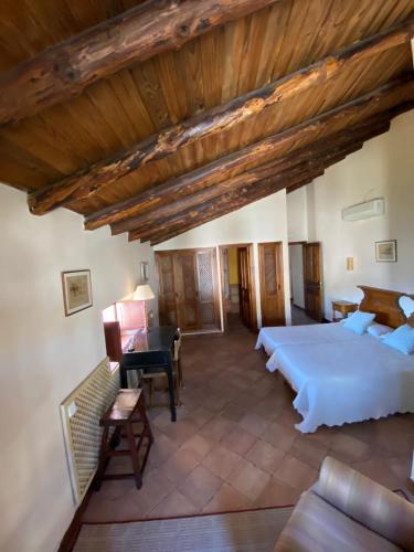 a large bedroom with two beds and a piano at Casa Jardín Sierra de Gata in Hoyos
