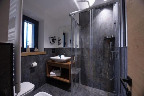 W łazience znajduje się szklana kabina prysznicowa i umywalka. w obiekcie Hotel Villa Melì w mieście Predazzo