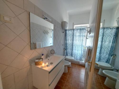 a bathroom with a white sink and two toilets at Relax Fiorella in Ladispoli
