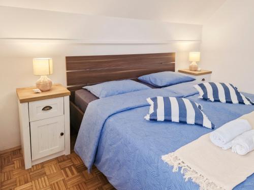 2 letti in una camera da letto con lenzuola e cuscini blu di Aparthouse SUPREME with Terme Catez Swimming Pools Tickets a Čatež ob Savi