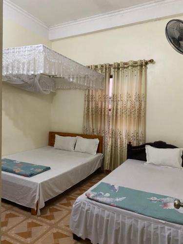 1 Schlafzimmer mit 2 Betten und einem Fenster in der Unterkunft Nhà nghỉ Minh Hạnh in Hoàng Ngà