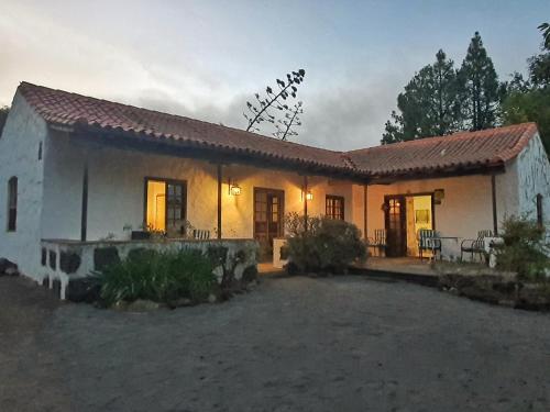una pequeña casa blanca con un patio frente a ella en Montañon Negro "casa MariaLuisa", en Agua de Fontanales