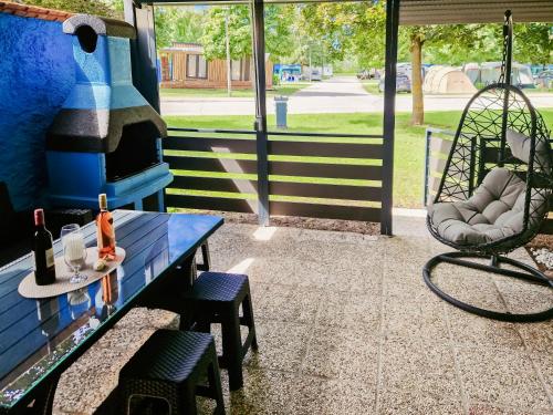 a porch with a blue bench and a swing at Aparthouse SUPREME with Terme Catez Swimming Pools Tickets in Čatež ob Savi