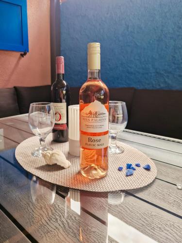 a bottle of wine and two glasses on a table at Aparthouse SUPREME with Terme Catez Swimming Pools Tickets in Čatež ob Savi