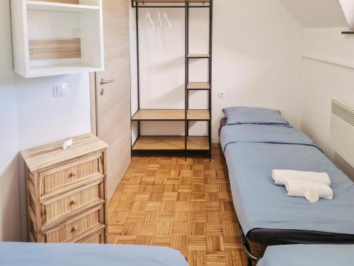 a room with two beds and a dresser and shelves at Aparthouse SUPREME with Terme Catez Swimming Pools Tickets in Čatež ob Savi
