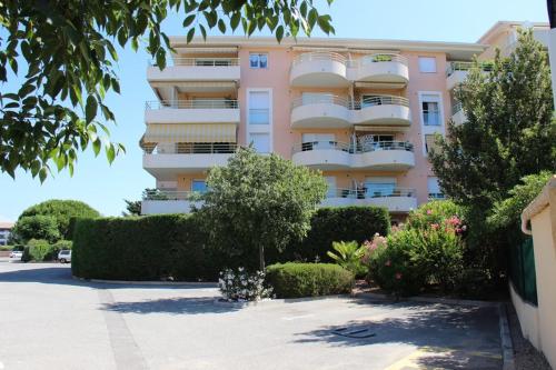 d'un immeuble rose avec balcon. dans l'établissement Appartement F4 en résidence Rez de Jardin, à Fréjus