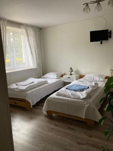 1 Schlafzimmer mit 2 Betten und einem TV an der Wand in der Unterkunft Przystawy Agroturystyka in Malechowo