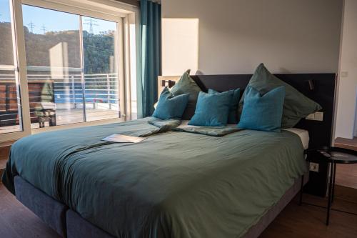 a bedroom with a bed with blue pillows and a window at Strandhaus Hagen in Hagen