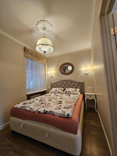 een slaapkamer met een bed en een kroonluchter bij Vilnius City Walls apartment in Vilnius