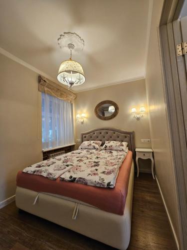 a bedroom with a bed and a chandelier at Vilnius City Walls apartment in Vilnius