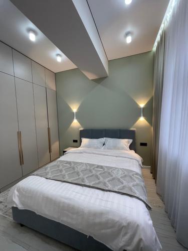 Un dormitorio con una cama grande con luces. en Rent Apartment en Bishkek