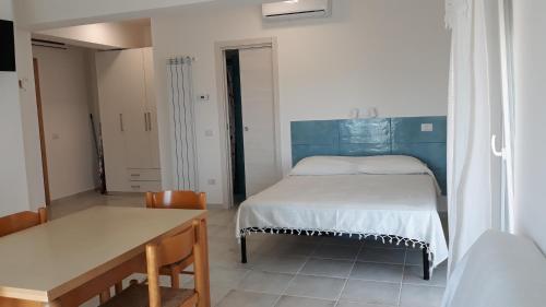 - une petite chambre avec un lit et une table dans l'établissement mare blu, à Gizzeria
