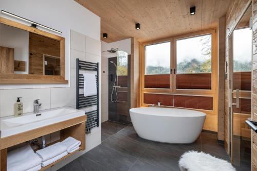 a bathroom with a large tub and a shower at Holzlodge deluxe in Radstadt
