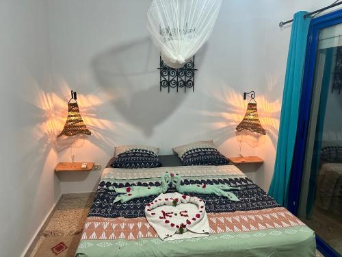 um quarto com uma cama com dois candeeiros em Appartement MANEL em Mezraya