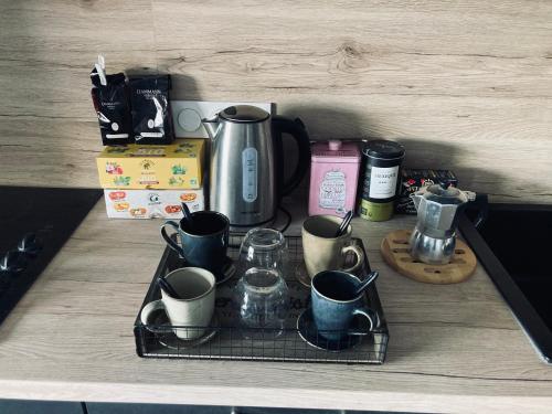 bandeja con tazas y tazas de café en una barra en Appartement 55m² avec vue sur Canigou et Parking, en Rivesaltes