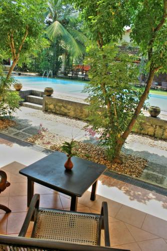 a table and chairs in front of a pool at Sandali Walauwa in Bentota