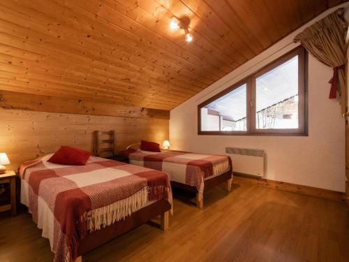 sypialnia z 2 łóżkami w drewnianym domku w obiekcie Appartement La Clusaz, 4 pièces, 6 personnes - FR-1-304-135 w mieście Clusaz