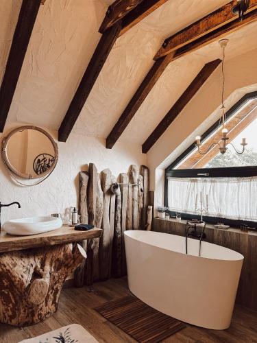 a bathroom with a large tub and a sink at Cuibul Braneanului in Bran