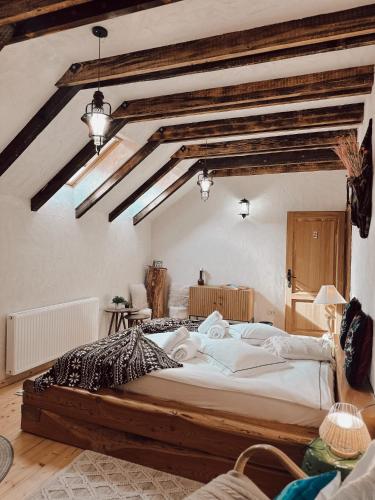 a large bed in a room with wooden beams at Cuibul Braneanului in Bran