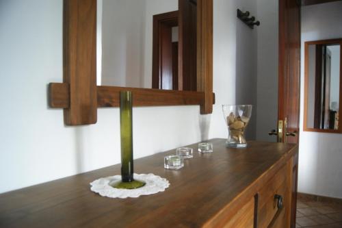 um balcão de madeira com um vaso e óculos em Casas del Monte em Valverde